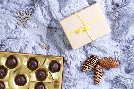 Christmas flatley. Gift box, chocolate candy cones and deer on a gray fur plaid.