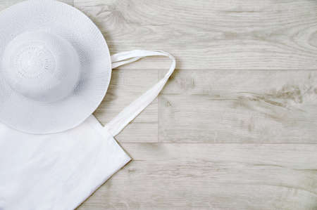 Zero waste concept. White cotton bag and straw hat on gray wooden boards.の写真素材