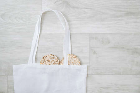 Zero waste concept. White cotton bag and two diet loaves on gray wooden boards.の写真素材