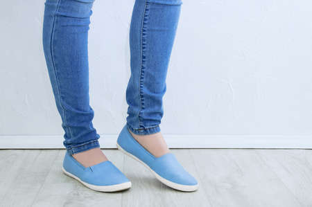 Clothes and footwear. Legs of a caucasian woman in skinny jeans and blue shoes close up.の写真素材