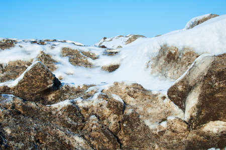 Melting blocks of snow during the afternoon, against the blue sky.の写真素材