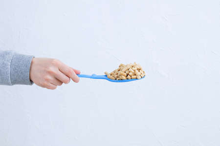 Cat litter litter on a blue scoop in the hand of a Caucasian woman.の写真素材