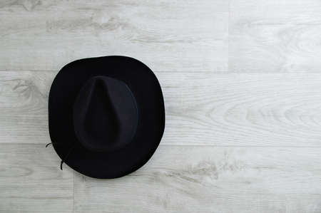 Black cowboy hat on a gray wooden background. Place for text.の写真素材