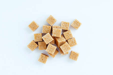 Cane sugar cubes heap close-up on a white background.の写真素材