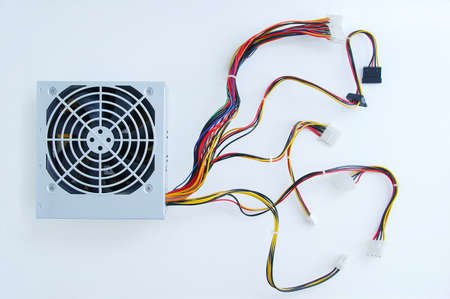 Power supply unit with wires for a personal computer close-up on a white background.