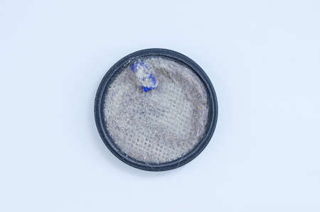 Round removable filter of the vacuum cleaner in dust on a white background.の写真素材