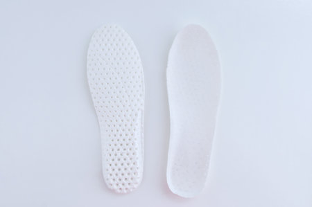 White textile insoles for shoes. White background.