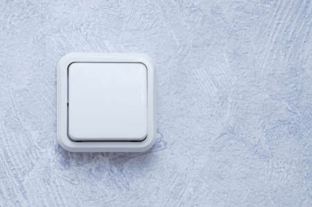 White electrical switch on a gray wall with wallpaper.の写真素材
