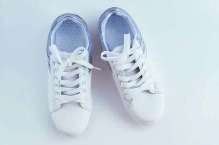 White sneakers with laces with silver inserts on a white background. View from above.の写真素材