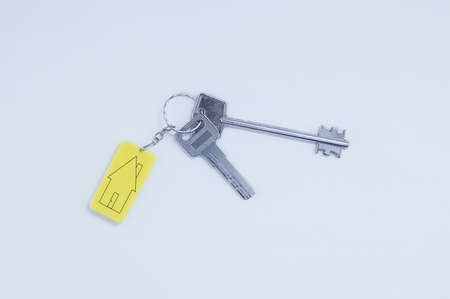 Real estate concept. Keychain with keys with black lines sketch of a house.の写真素材