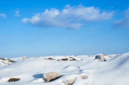 Snowy winter landscape in the mountains with blue sky with clouds. During the afternoon in sunny...
