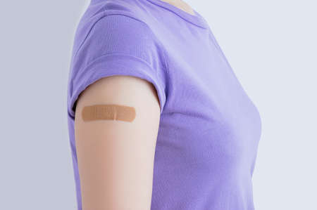 The hand of a Caucasian woman is sealed with a medical plaster on the forearm. After vaccination.の写真素材