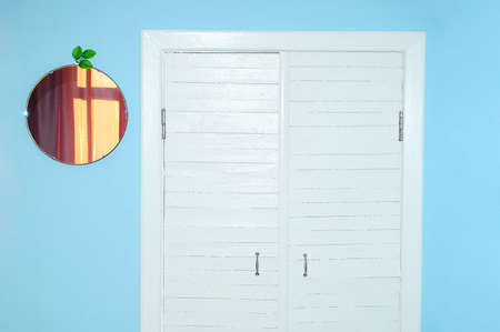Built-in wardrobe doors and mirror on the blue wall. The interior of the room.の写真素材