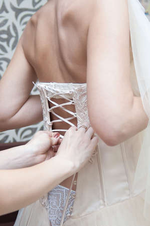 Caucasian woman lace up corset on bride dress.の写真素材