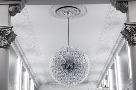 Large ceiling glass round chandelier in the foyer of the room with columns.の写真素材