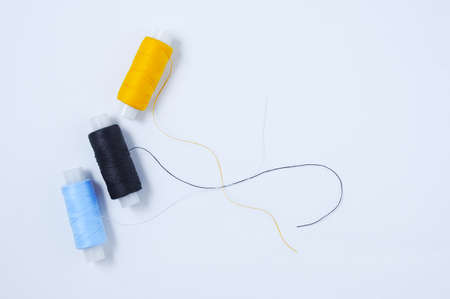 Three spools of multicolored sewing thread. white background.の写真素材