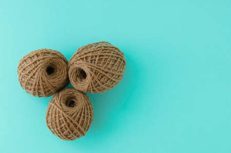 Three brown skins of yarn. Turquoise background. Place for text.の写真素材