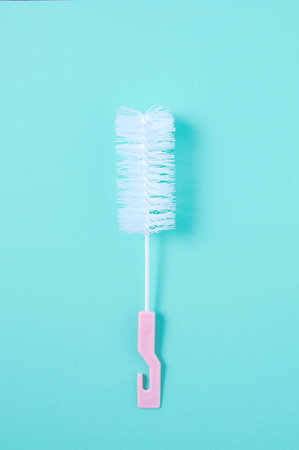 Bottle cleaner with pink handle. Turquoise background.の写真素材