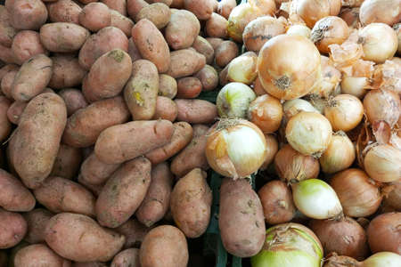 Potatoes and onions on the counter of the store.の写真素材
