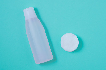 Facial lotion and cotton pads. view from above. Turquoise background.の写真素材