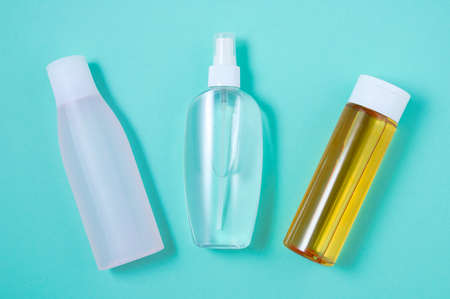 Three bottles of face lotion. Turquoise background. view from above.の写真素材
