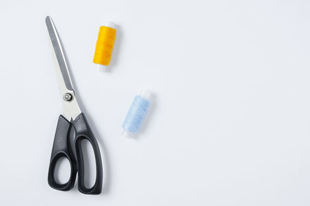 Fabric scissors and sewing thread. white background. view from above. Place for text.の写真素材