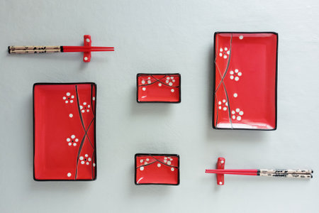 Red ceramic set of plates for sushi and rolls on a gray background. View from above.の写真素材