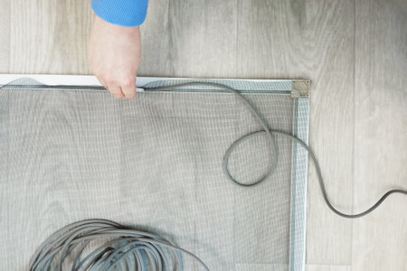 Mosquito net and metal profile.Tucks rubber cord for mosquito net on white wooden background.