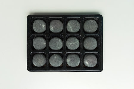Gray items in black packaging. White background. Top view.の写真素材