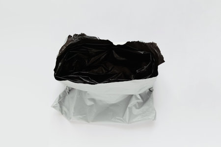 Opened packaging bag gray black color. White background.