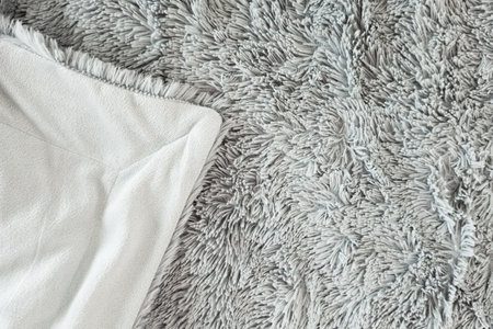 Gray fur, shaggy bedspread. Corner of the bedspread with lining on the back.の写真素材