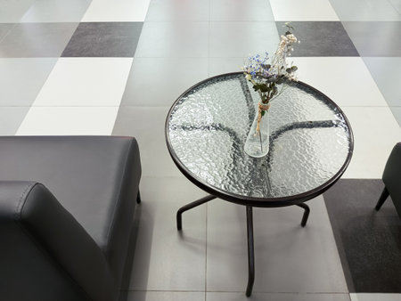 Interior of a public space. Leather gray sofas, a table with a glass top and a vase with flowers.の写真素材