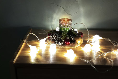 Glow in the dark garland on the table top of the chest of drawers and decorative Christmas...