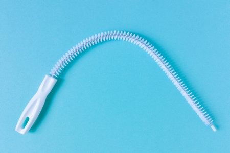 A thin pipe cleaner. Blue background.