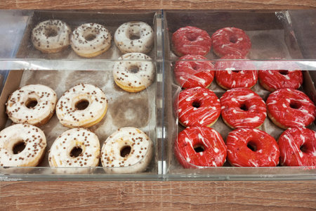 Donuts with white and red cream in a shop window.の写真素材
