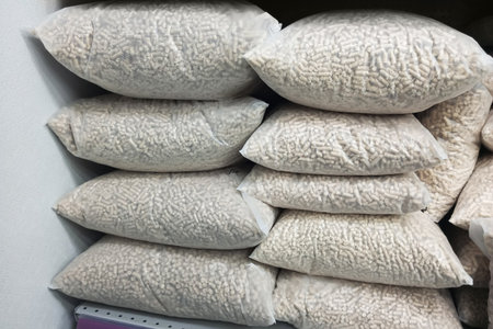 Wood cat litter in large clear bags stacked on a shelf in the pantry.