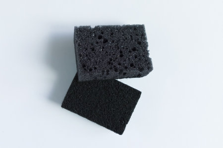 Two gray dishwashing sponges. Porous and abrasive sides. White background.の写真素材