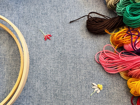 Embroidered flowers on fragment of blue denim jeans textureの写真素材