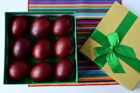 Easter colored red eggs are in a beautiful gift box. Easter symbol, holiday treat, giftの写真素材