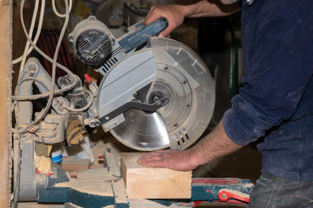 Production of custom-made wooden furniture. The master carpenter performs cutting of workpieces on a...