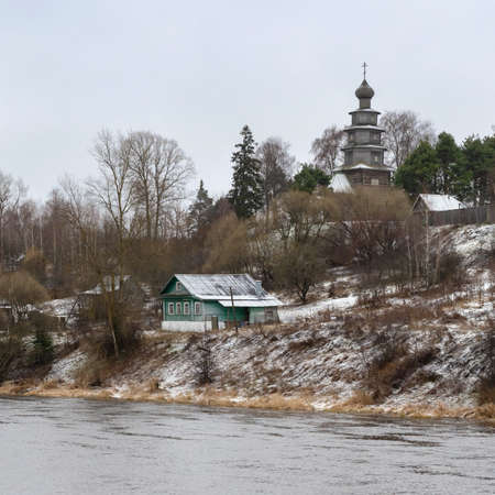 beautiful landscape overlooking embankment with small houses and an old wooden temple in late autumn. Architecture of small town Torzhok. Russia. Tver regionの写真素材