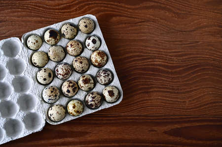 quail eggs in cardboard packaging on wooden background. top view. The idea of healthy breakfast, symbol of Easter. copy spaceの写真素材