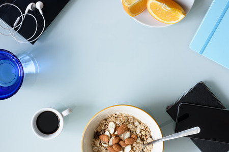 Morning coffee, breakfast, laptop and office supplies on office desk. Top view, copy space.の写真素材