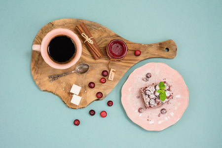 Coffee and chocolate dessert with cranberry jam and cinnamon on wooden board, over turquoise background. Top view.の写真素材