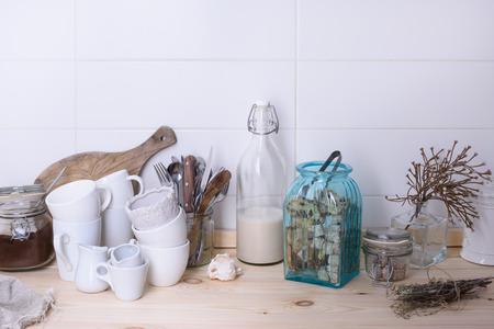 Scandinavian style still life of kitchenware on a wooden buffet counter. White background, copy space.の写真素材