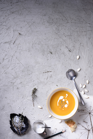 Sweet and spicy roasted kabocha squash soup served with herbs,  sour cream and bread crouton. Top view, copy space.の写真素材