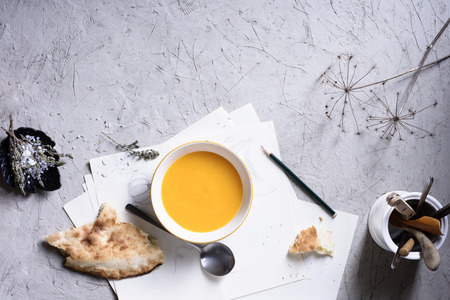 Roasted pumpkin and carrot soup with bread and herbs on grey concrete background. Copy space, top viewの写真素材