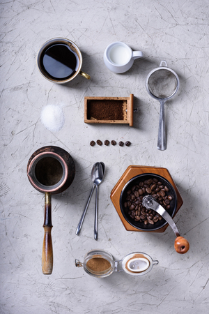 Morning coffee cup,  beans, milk, turkish pot, grinder. Flat lay coffee making set. Top view, mock up.の写真素材