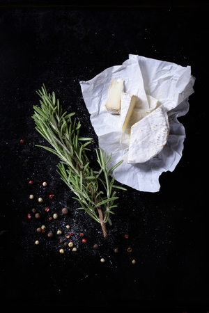 Bunch of garden fresh herbs with cheese on rustic black board from above.の写真素材