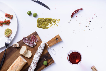Salami, olives and baguette. Traditional spanish fuet snack. Above view, white background.の写真素材